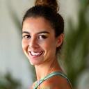 Headshot of Maria, a kind and experienced female yoga instructor, smiling warmly.
